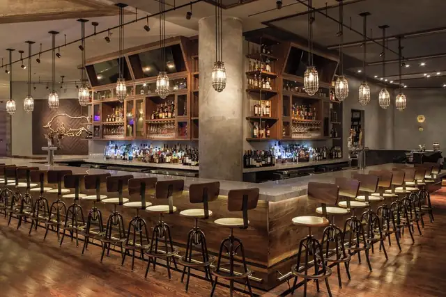 InterContinental Miami em Miami, bar com balcões de madeira e luminárias suspensas