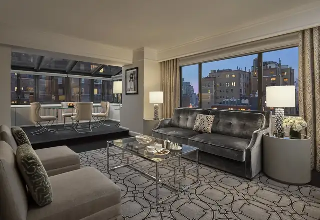 Loews Regency em Nova York, sala moderna com sofá, poltronas e mesa de vidro