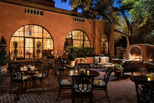 Rosewood Mansion em Dallas, pátio externo com piso de tijolo, cadeiras e mesas