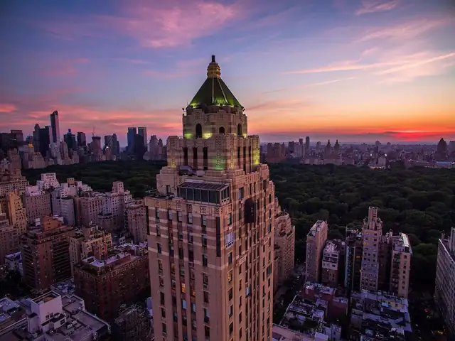 The Carlyle em Nova York, edifício alto com torre iluminada de verde