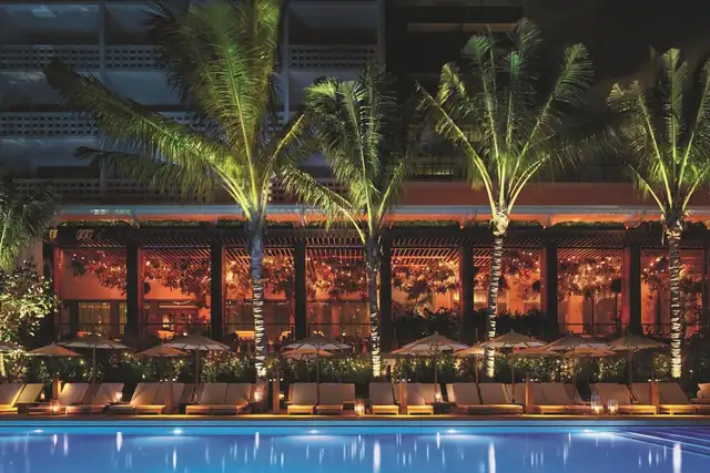 The Miami Beach EDITION em Miami, área da piscina com espreguiçadeiras e guarda-sóis