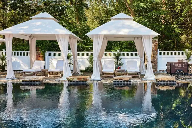 White Barn Inn em Kennebunkport, piscina com dois gazebos brancos e espreguiçadeiras